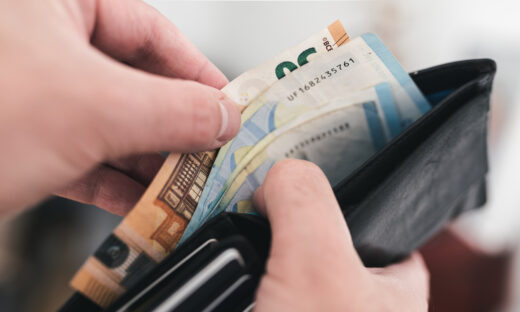 close-up view of hands taking money out of a wallet