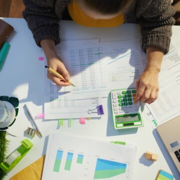 accountant woman with calculator and documents working in office