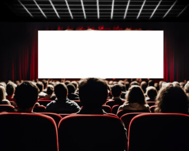 Cinema blank screen and people in red chairs in the cinema hall