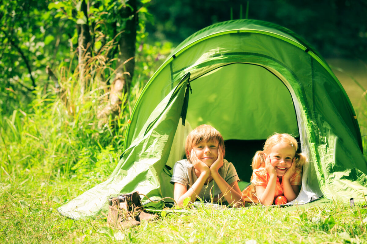 brother and sister are lying inside their tent