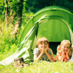 brother and sister are lying inside their tent