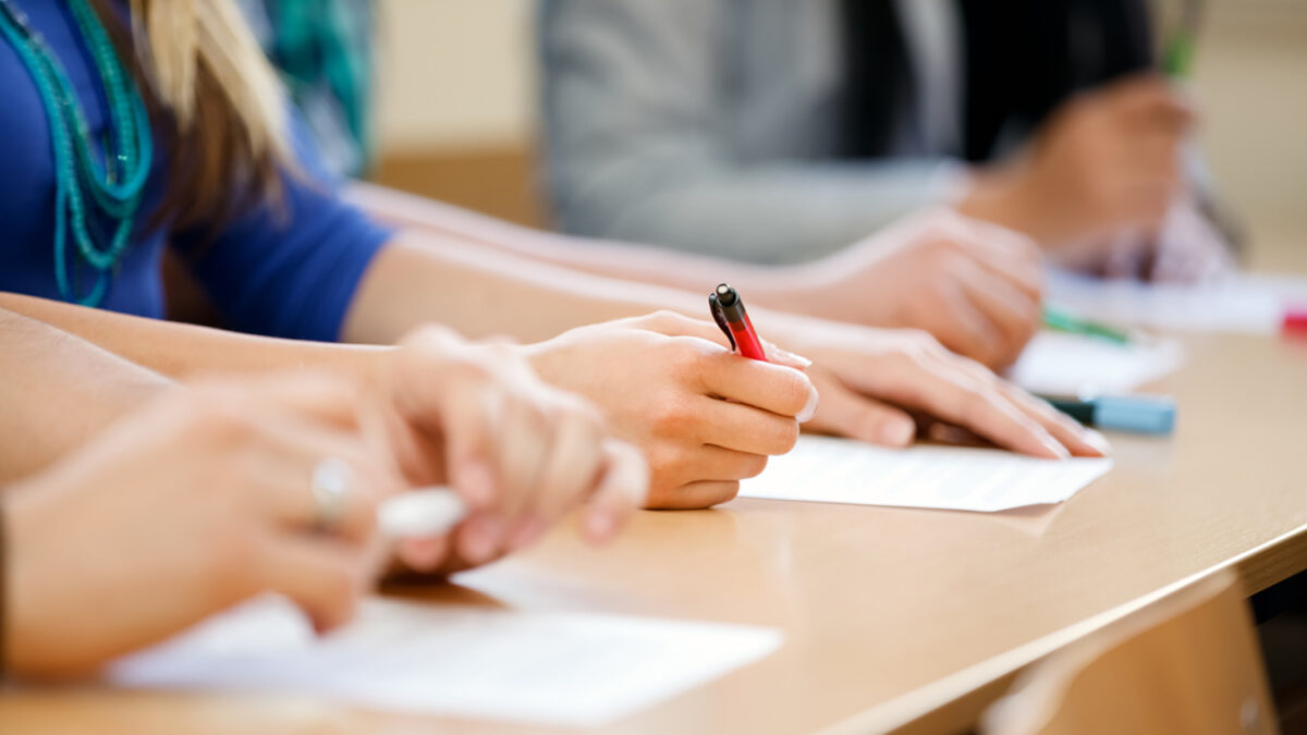 Close-up of writing hands of students at course