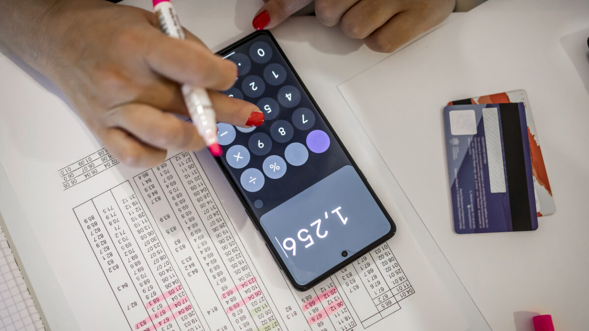 An adult unrecognized woman calculating her bills at home