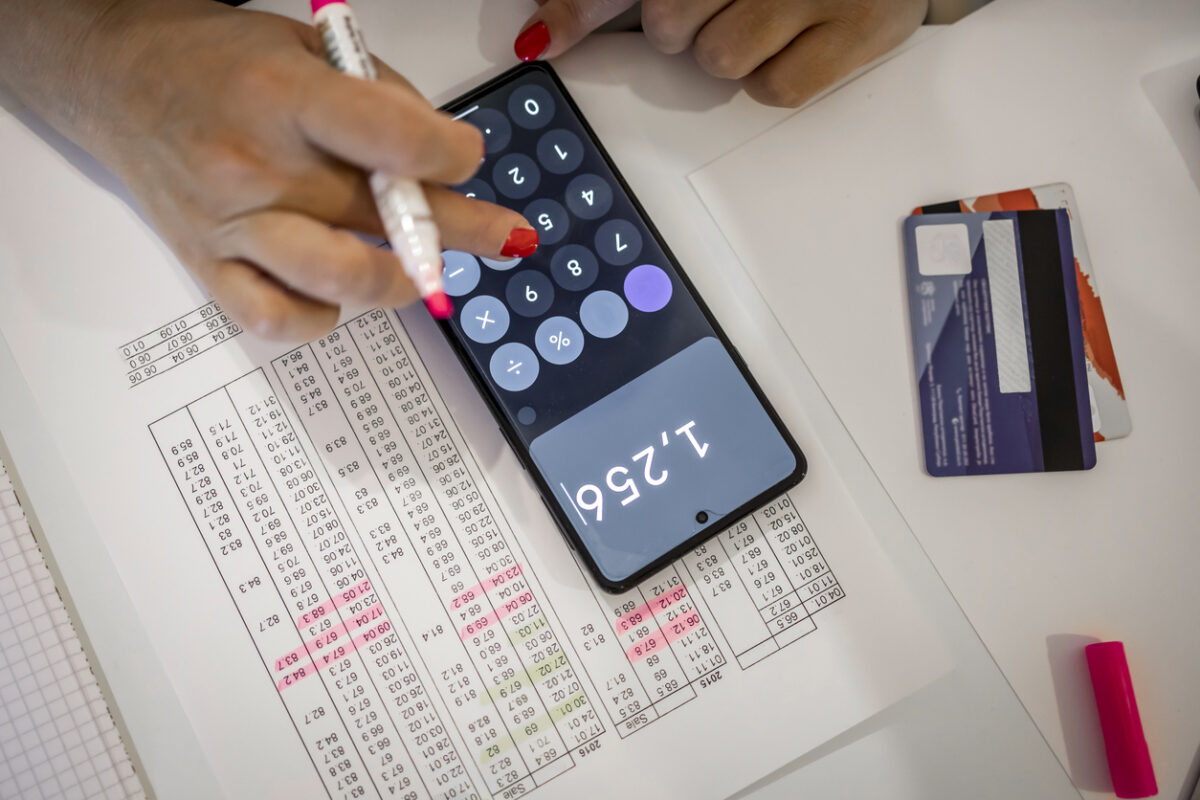 An adult unrecognized woman calculating her bills at home