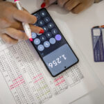An adult unrecognized woman calculating her bills at home