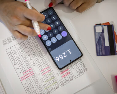 An adult unrecognized woman calculating her bills at home
