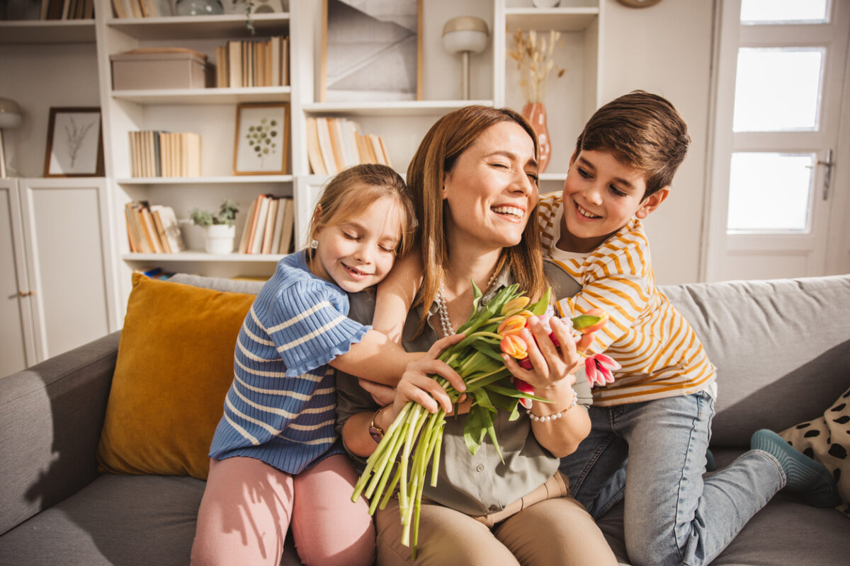 Happy kids giving bouquet of tulips to their mother for mother's day.