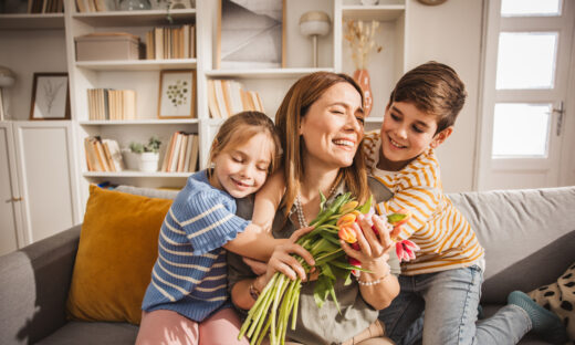 Happy kids giving bouquet of tulips to their mother for mother's day.