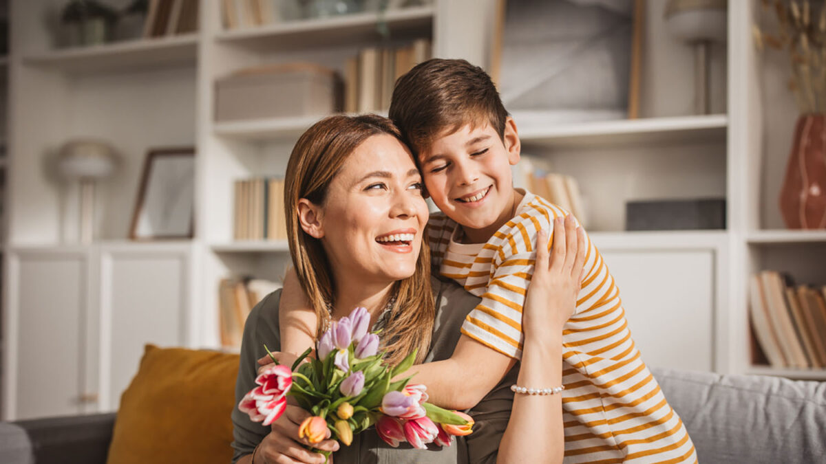 Happyx son giving bouquet of tulips to his mother for mother's day.