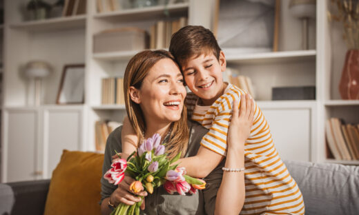 Happyx son giving bouquet of tulips to his mother for mother's day.