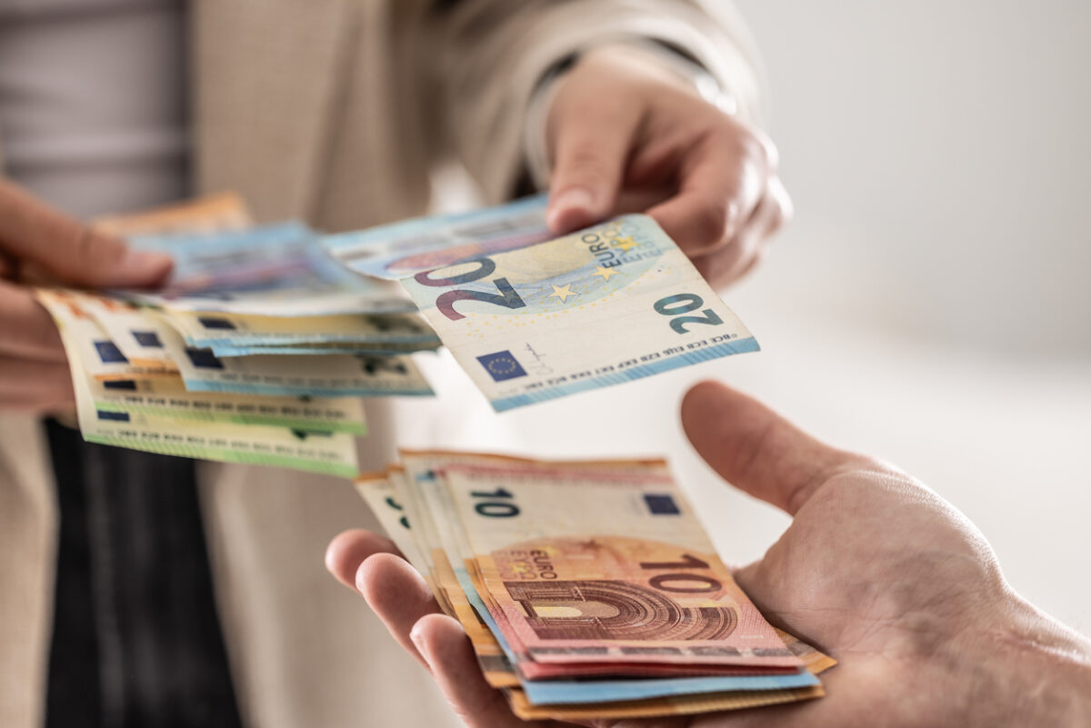 Businesswoman's hands exchanging euro banknotes