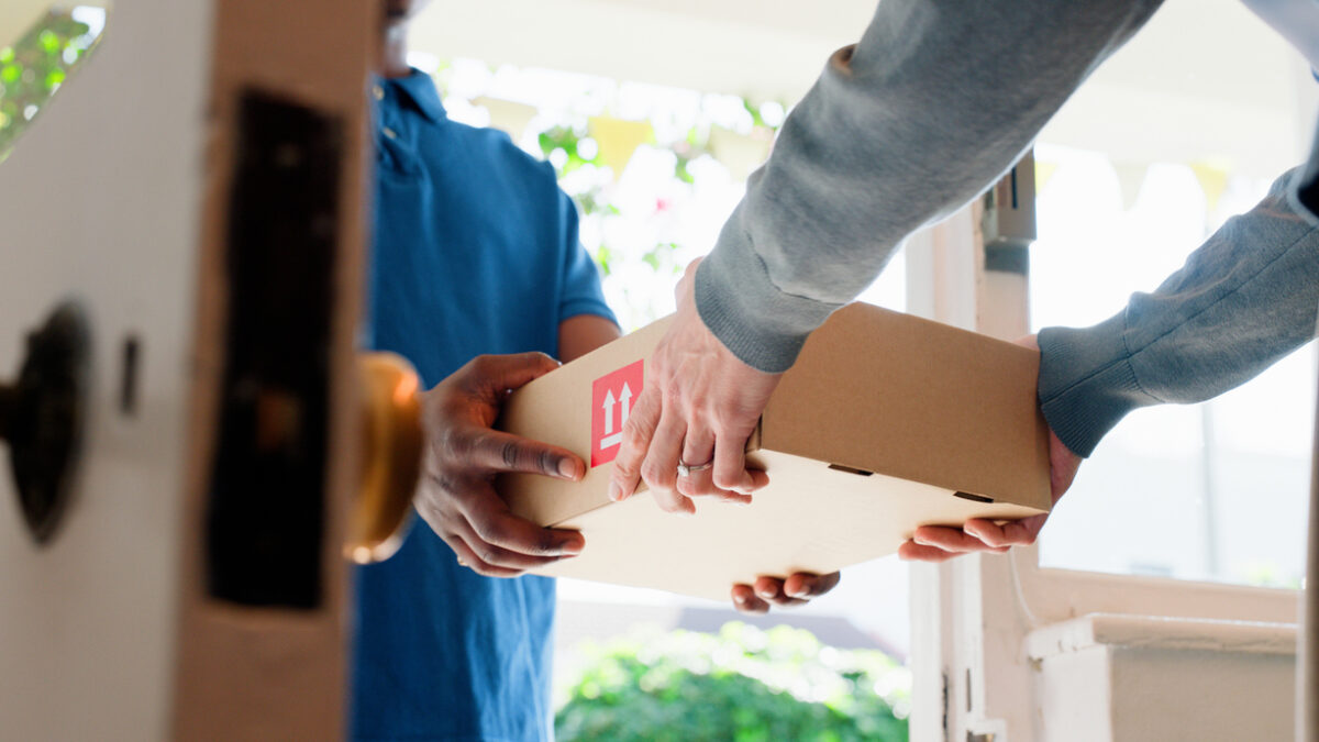 Hands, box and delivery man at front door in home with client, services and shipping for commercial product