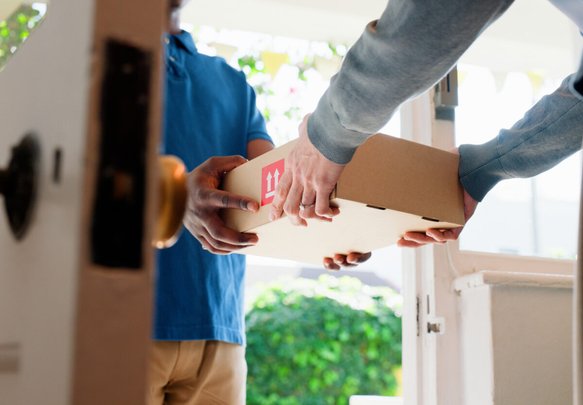 Hands, box and delivery man at front door in home with client, services and shipping for commercial product