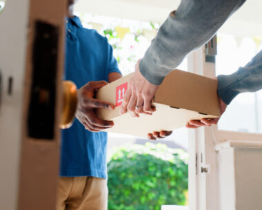 Hands, box and delivery man at front door in home with client, services and shipping for commercial product