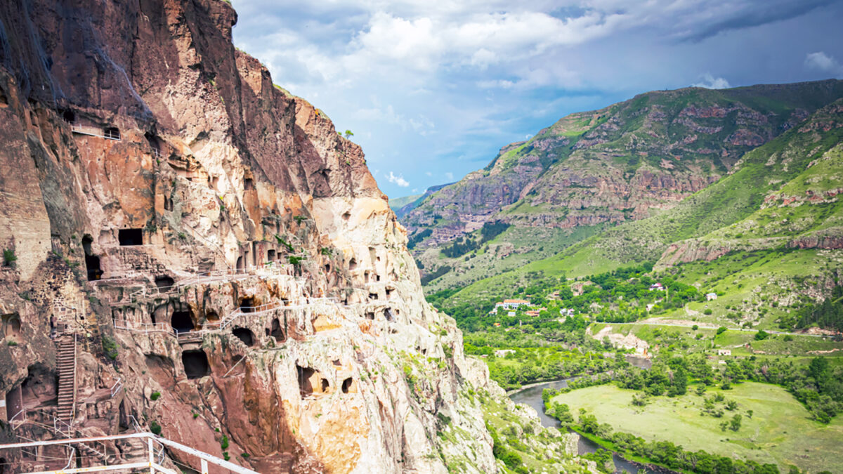 Vardzia city caves with green canyon in background in summer. Famous travel destination