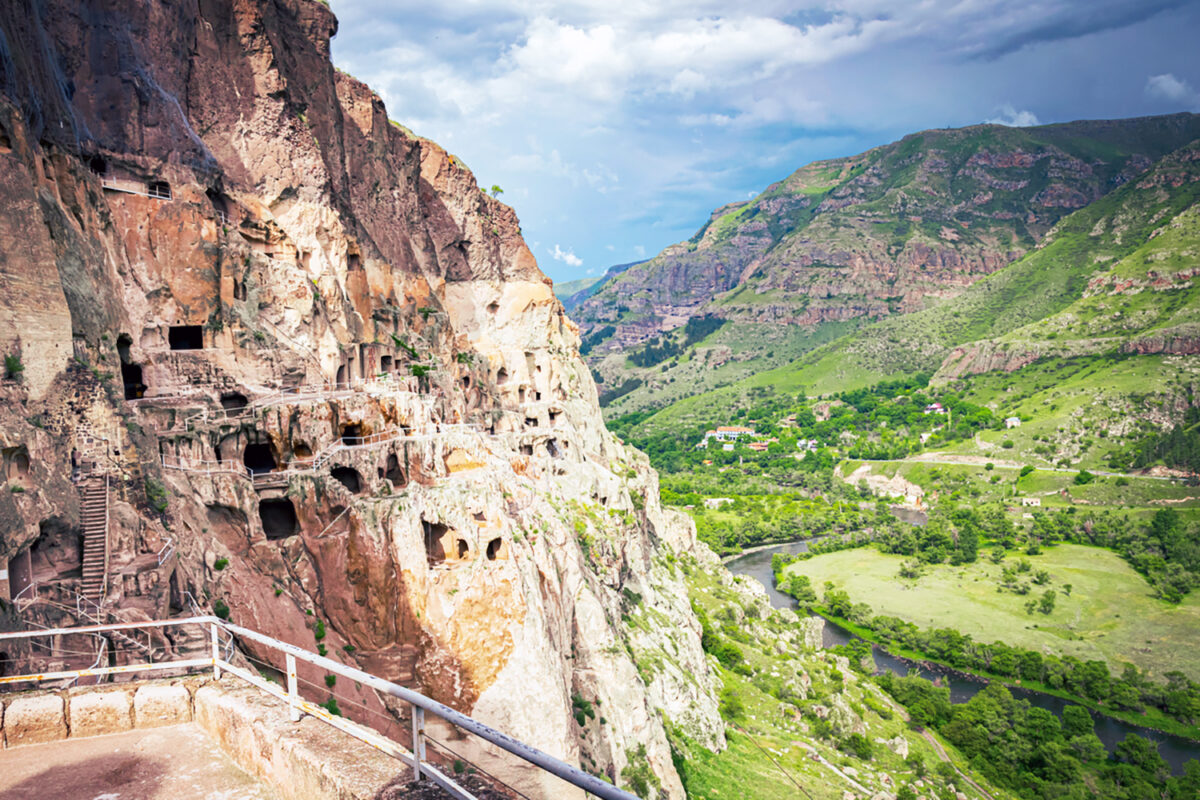 Vardzia city caves with green canyon in background in summer. Famous travel destination