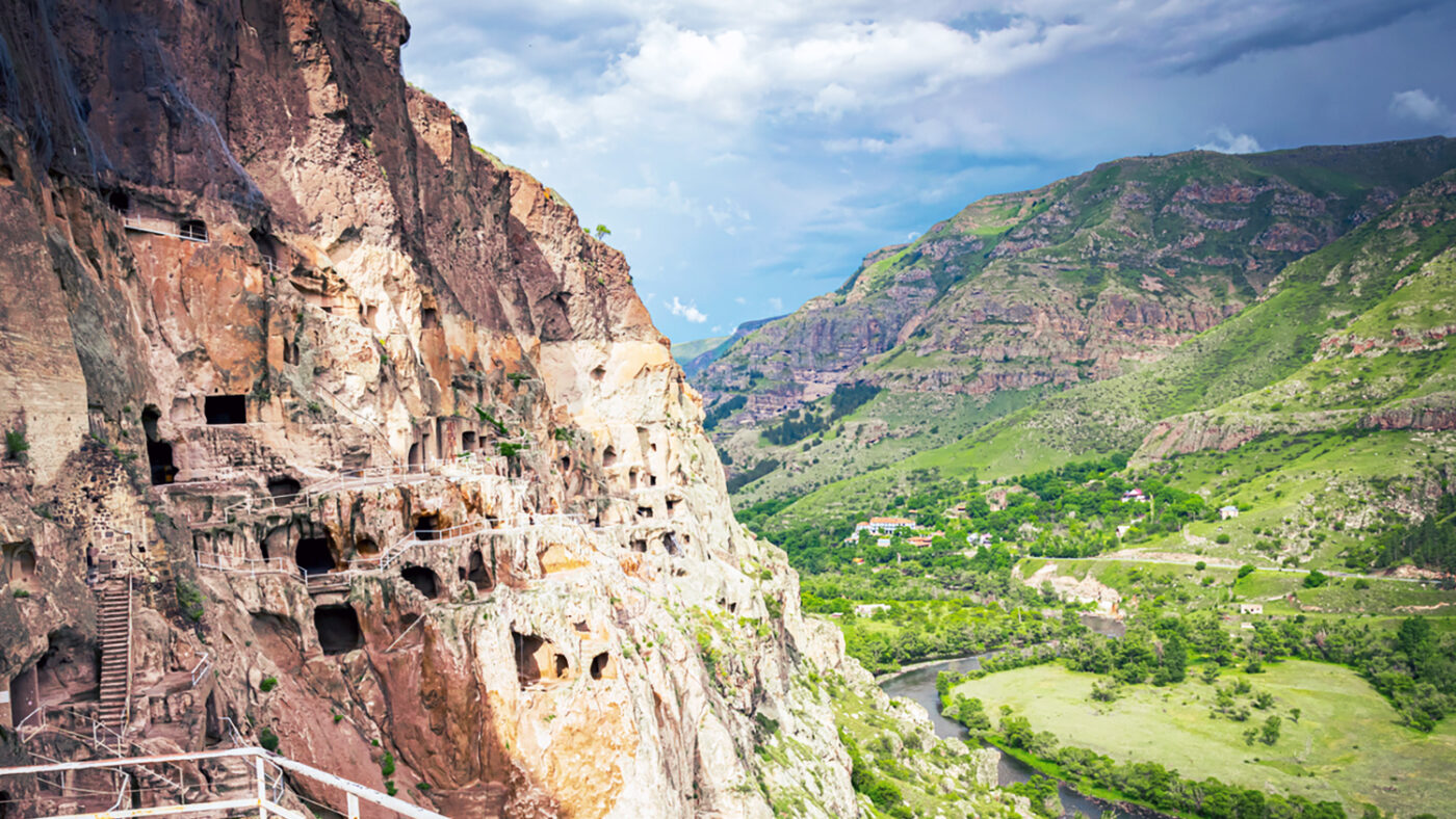 Vardzia city caves with green canyon in background in summer. Famous travel destination