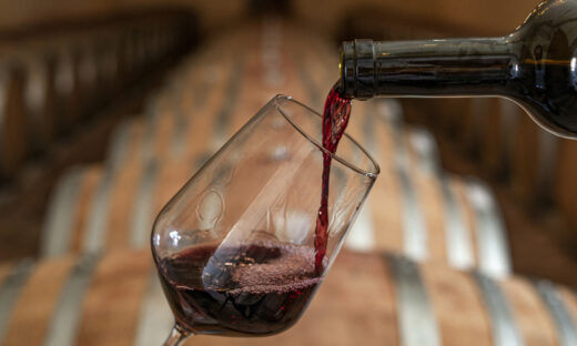Pouring red wine into the glass in the cellar