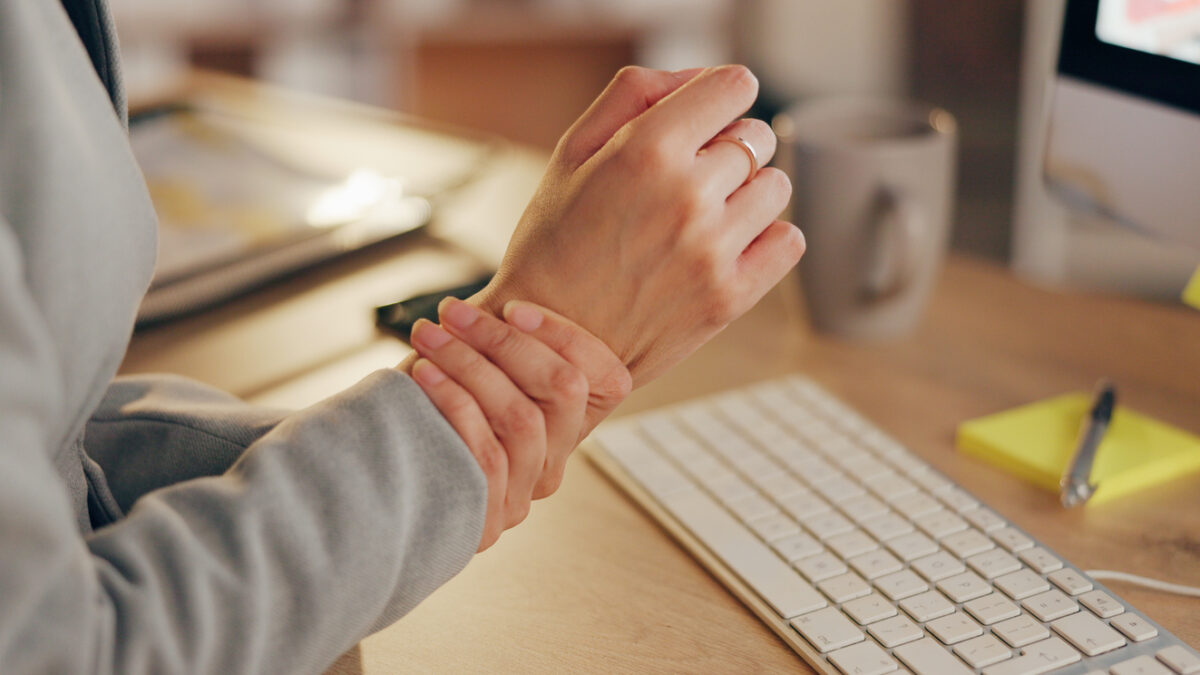 Wrist pain, office and hands on business person with injury, strain and accident for typing on keyboard. Professional, corporate and worker with ache, spasm and medical crisis for carpal tunnel