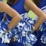 Cheerleaders in Uniform Holding Pom-Poms