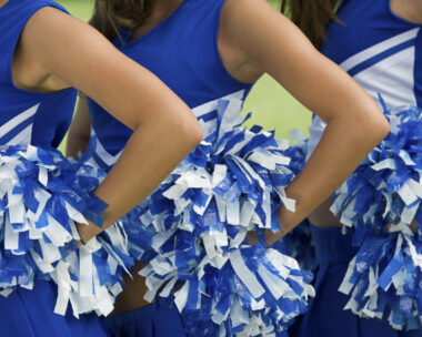 Cheerleaders in Uniform Holding Pom-Poms