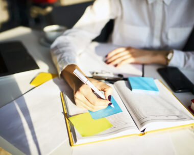 Cropped image of creative female secretary creating planning for executive noting important meeting and events organizing work of busy boss while sitting at working place in coworking office
