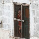 Γυναίκα κοιτά από το παράθυρο το Κασμίρ που «φλέγεται»