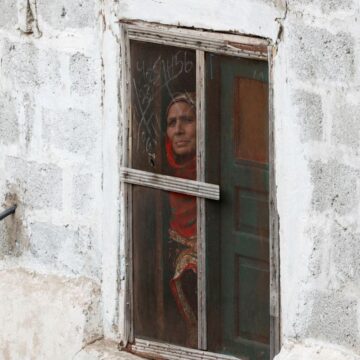 Γυναίκα κοιτά από το παράθυρο το Κασμίρ που «φλέγεται»