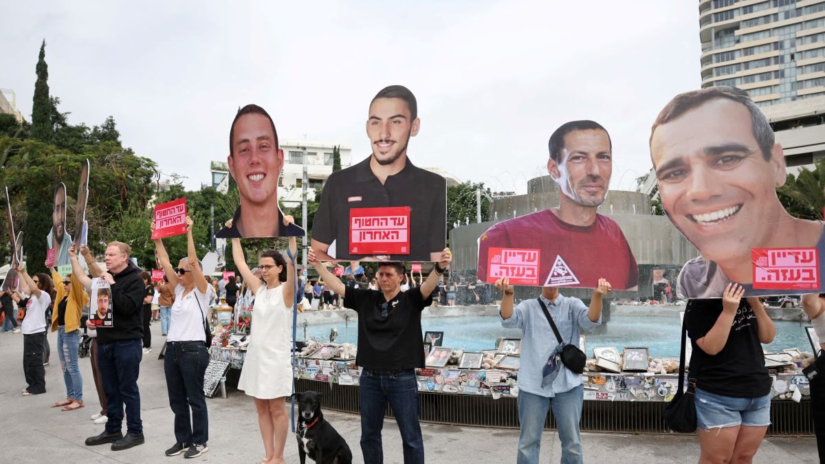 Ισραηλινοί πολίτες με τις φωτογραφίες ομήρων που παραμένουν στη Γάζα