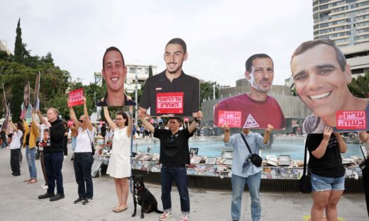 Ισραηλινοί πολίτες με τις φωτογραφίες ομήρων που παραμένουν στη Γάζα