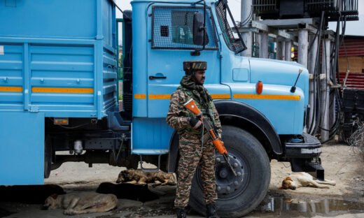 An Indian security force personnel stands guard on a street next to sleeping dogs, following the Pahalgam attack in south Kashmir, in Srinagar, May 5, 2025. REUTERS