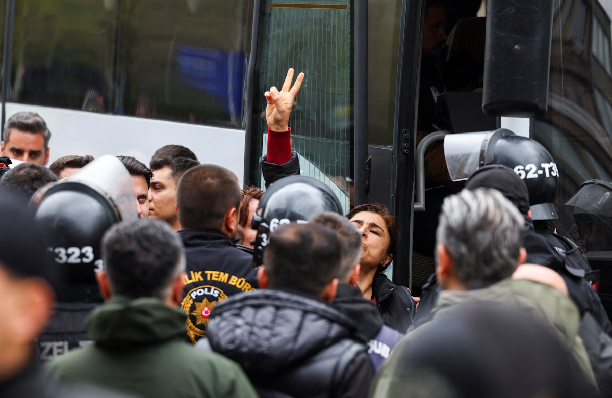 A demonstrator makes gestures as it is held, on the day people try to defy the ban and march to Taksim Square to celebrate May Day