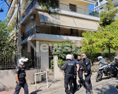 Αστυνομικοί έξω από την πολυκατοικία όπου βρίσκεται το διαμέρισμα όπου ο 50χρονος δολοφόνησε την ηλικιωμένη μητέρα του