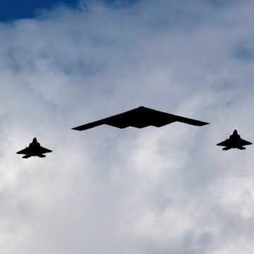 Ένα βομβαρδιστικό B-2 Spirit Stealth πλαισιώνεται από τέσσερα μαχητικά αεροσκάφη F-22 Raptor