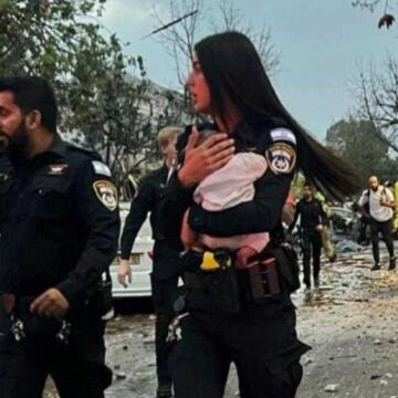 Αστυνομικός κρατά στην αγκαλιά της το βρέφος που διασώθηκε από τους βομβαρδισμούς του Ιράν