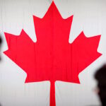 People are silhouetted in front of the Canadian national flag at the Palais des Congres in Montreal, Quebec, Canada October 21, 2019.
