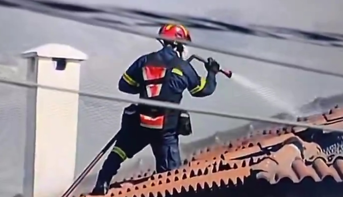 Ο πυροσβέστης πάνω στην σκεπή στην Παλαιά Φώκαια