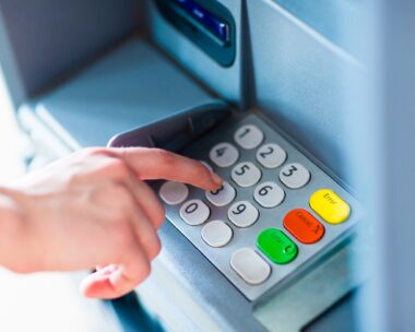 Close-up of hand entering PIN/pass code for a money transfer, on a ATM/bank machine keypad outside