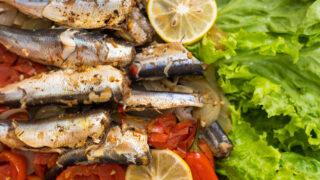 Fish stewed in vegetables with lemon. Culinary background with selective focus and blurred background.