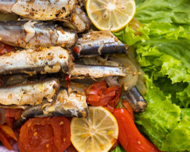 Fish stewed in vegetables with lemon. Culinary background with selective focus and blurred background.