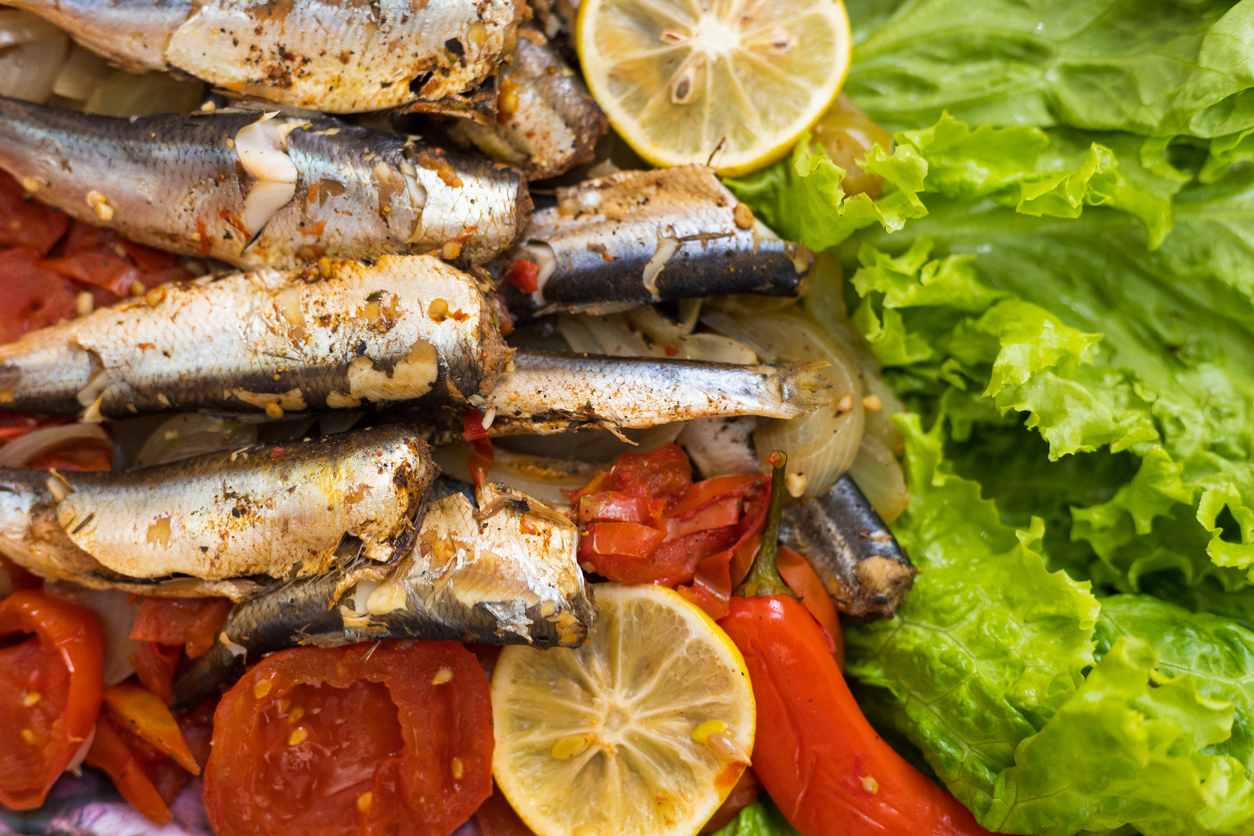 Fish stewed in vegetables with lemon. Culinary background with selective focus and blurred background.