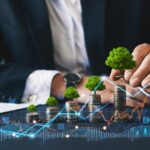 Eco business investment. Green business growth. Businessman holding coin with tree growing on money coin stack. Finance sustainable development. Concept of pass and increase of renewable energy
