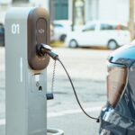 Electric cars on chargers on modern public parking