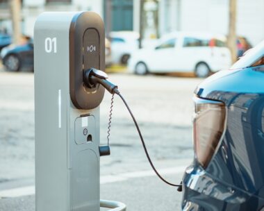 Electric cars on chargers on modern public parking