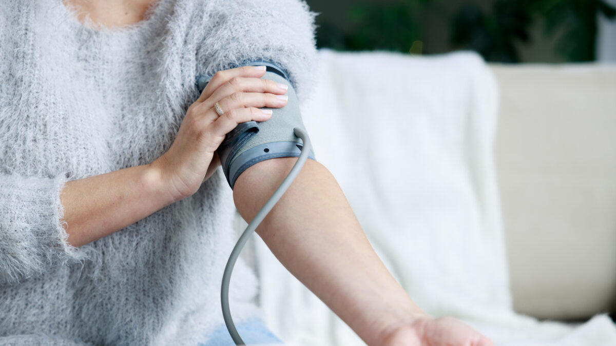 Young woman checking her blood pressure at home