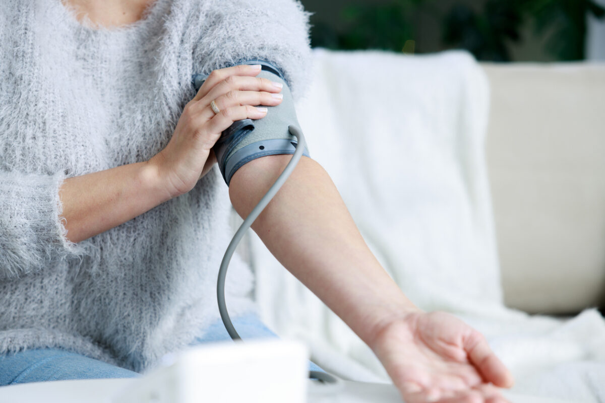 Young woman checking her blood pressure at home