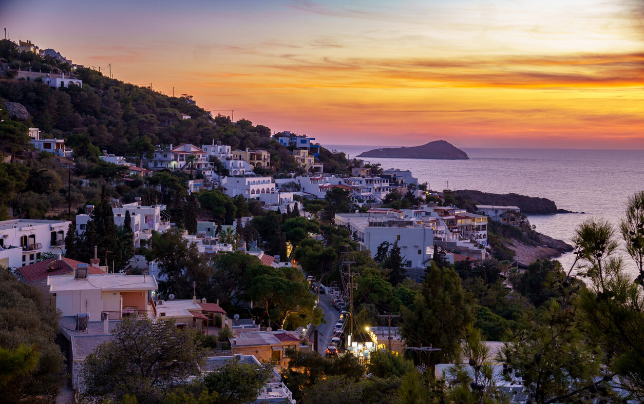 Sunset on Kalymnos, Greece. View over the village of Massouri to the sea with orange colored sky of the setting sun