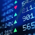 Financial data analysis graph showing stock market trends on a trading board. Horizontal composition with copy space and selective focus.