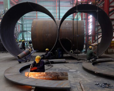 A worker cuts a metal plate inside an industrial tank manufacturing factory on the outskirts of Ahmedabad, India, January 31, 2025.