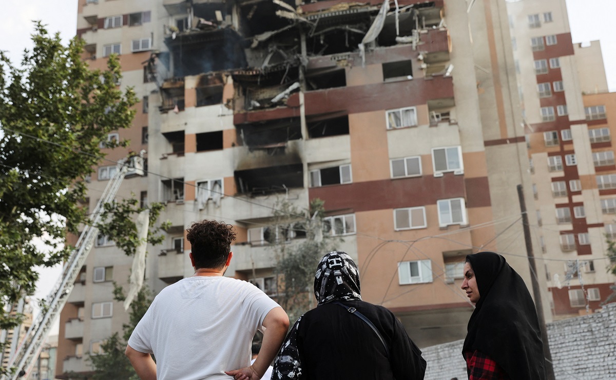 Άνθρωποι μπροστά από κατεστραμμένο κτίριο στην Τεχεράνη